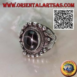 Silver ring with oval black star on ethnic setting with balls and leaves on the sides