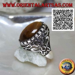 Silver ring with large cabochon oval tiger eye surrounded by mystical bas-relief decorations