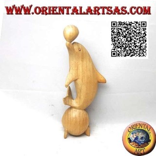 Sculpture of a dolphin juggling between two 20 cm hibiscus wood balls