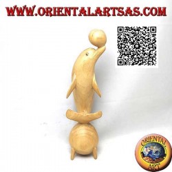 Skulptur eines Delfins, der zwischen zwei 20 cm Hibiskusholzkugeln jongliert
