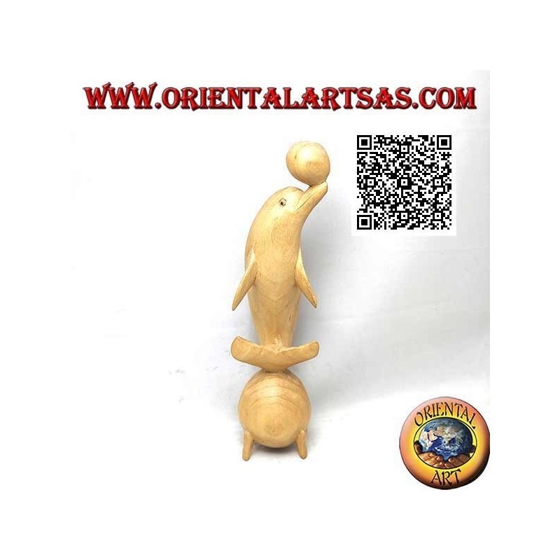 Sculpture of a dolphin juggling between two 20 cm hibiscus wood balls