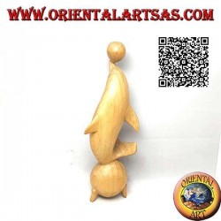 Escultura de un delfín haciendo malabares entre dos bolas de madera de hibisco de 20 cm