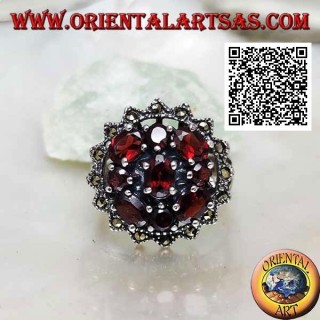 Anillo de plata con granate ovalado rodeado de granates redondos y ovalados en un sol de marcasita