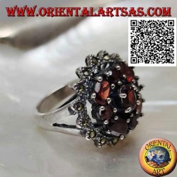 Anillo de plata con granate ovalado rodeado de granates redondos y ovalados en un sol de marcasita