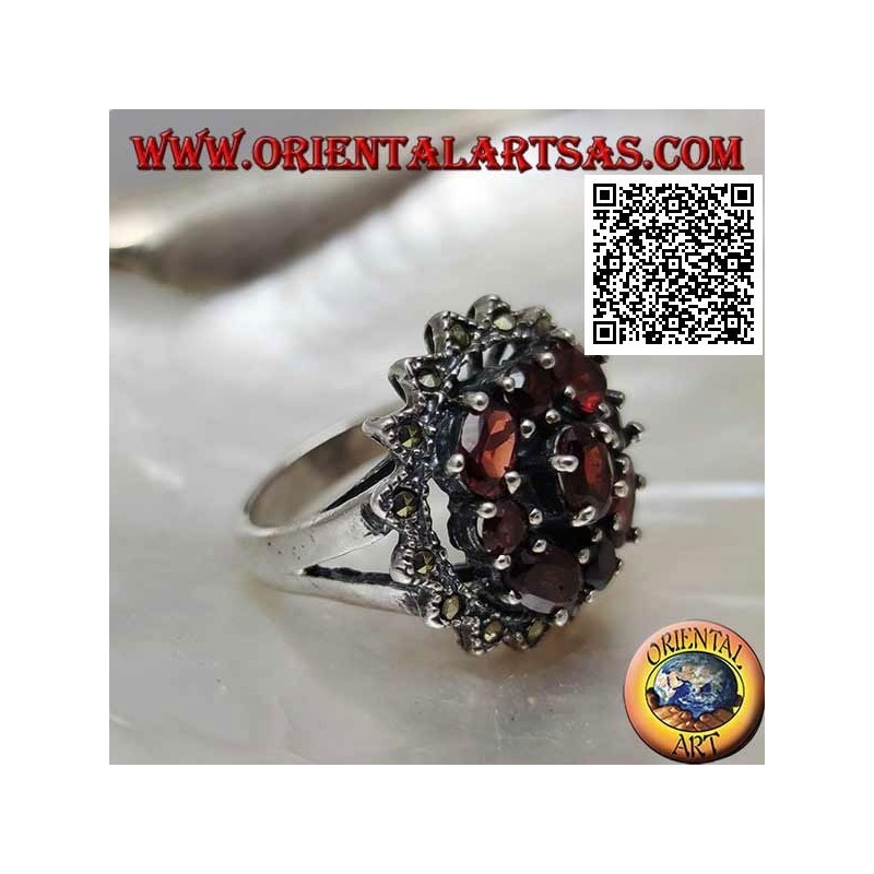 Bague en argent avec grenat ovale entouré de grenats ronds et ovales sous un soleil de marcassite