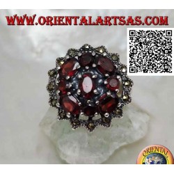 Bague en argent avec grenat ovale entouré de grenats ronds et ovales sous un soleil de marcassite