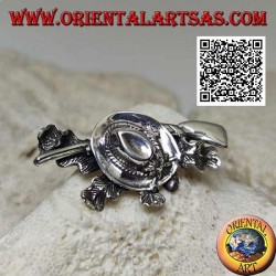 Silver brooch of the hunter with hat and shotgun on a carpet of ivy