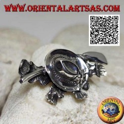 Silver brooch of the hunter with hat and shotgun on a carpet of ivy