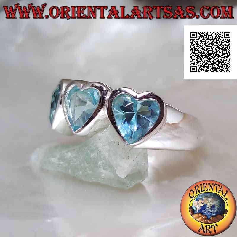 Smooth rhodium silver ring with three synthetic blue topaz hearts