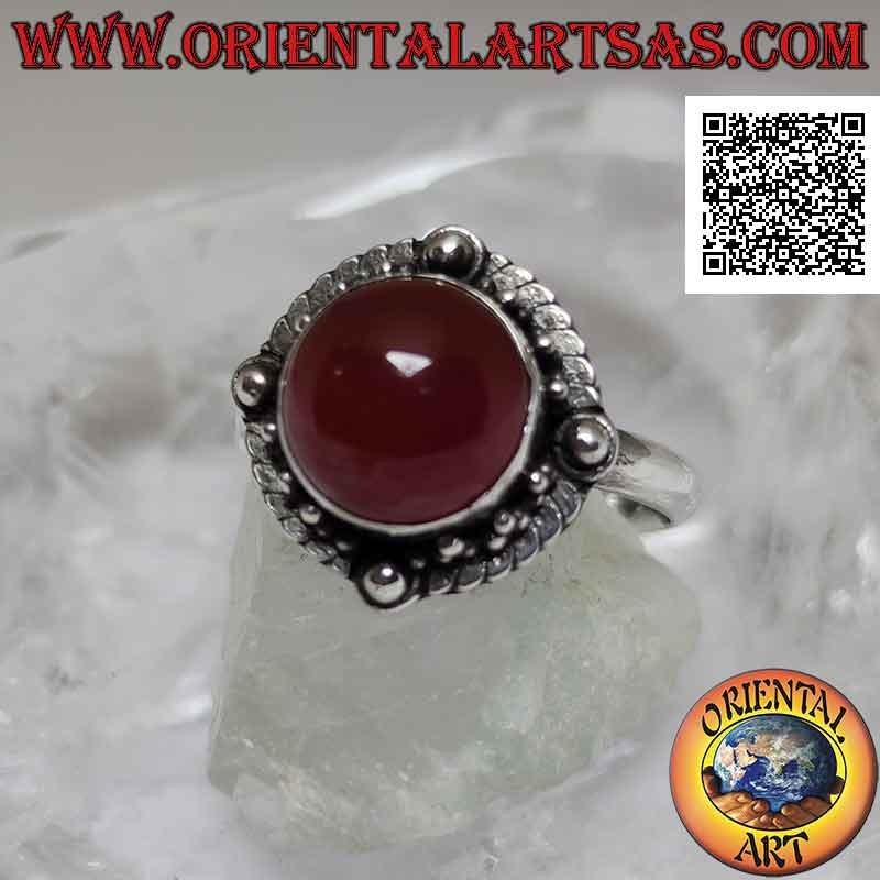 Silver ring with round cabochon carnelian surrounded by interlacing and ball on the four cardinal points