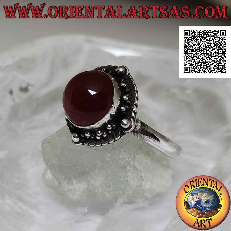 Silver ring with round cabochon carnelian surrounded by interlacing and ball on the four cardinal points