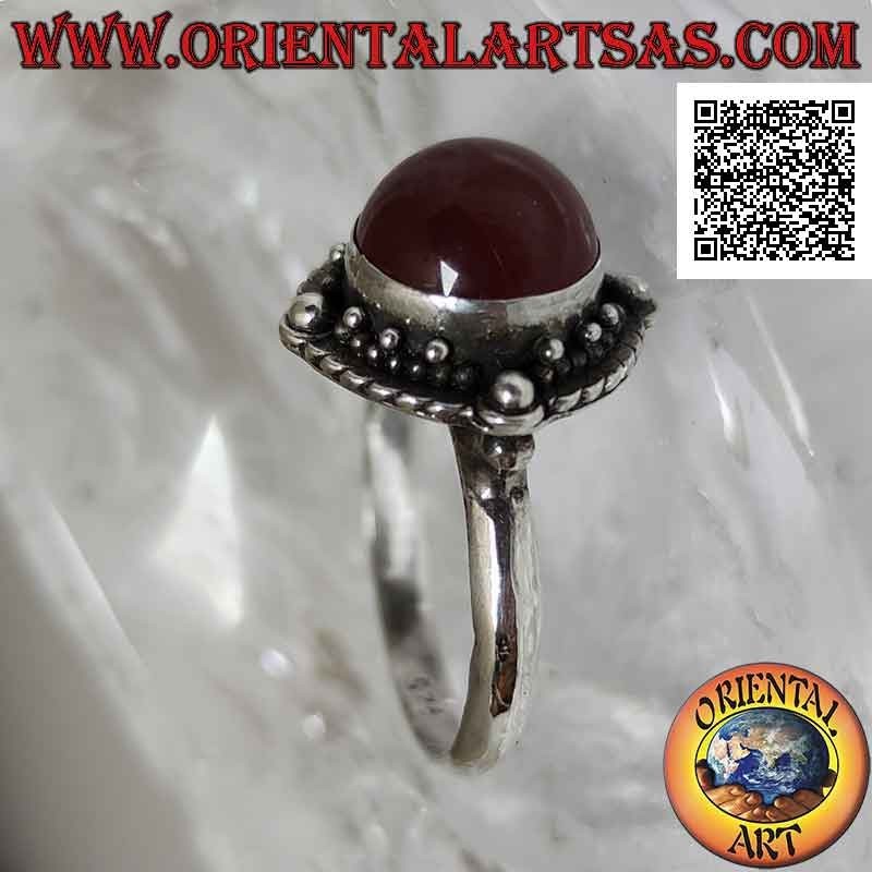 Anello in argento con corniola tonda cabochon contornata da intreccio e pallina sui quattro punti cardinali