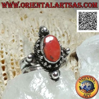 Anello in argento con corallo antico ovale contornato da tris di palline e intreccio e tris sui punti cardinali