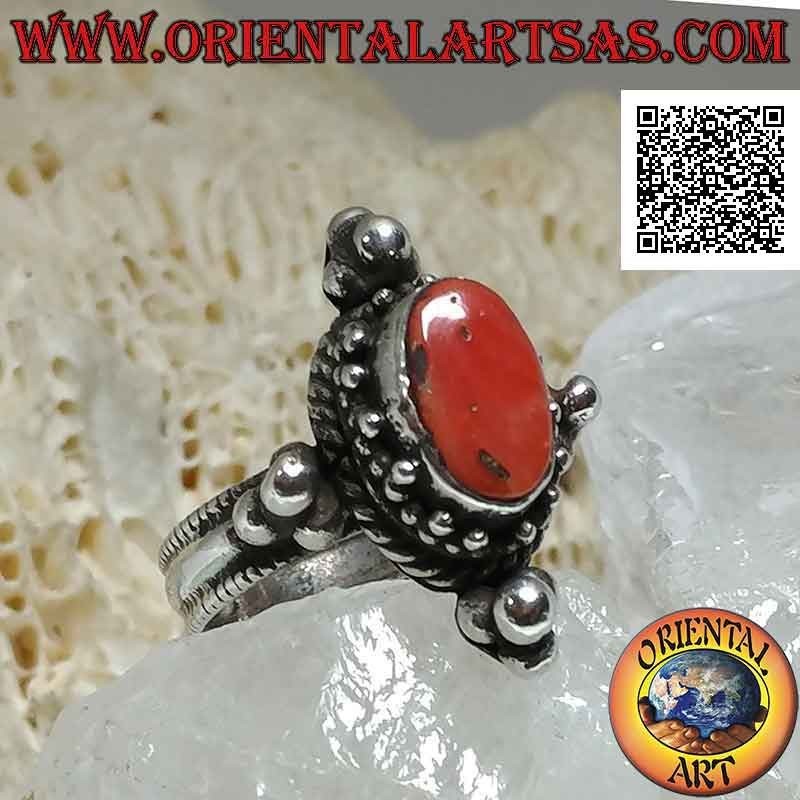 Silver ring with oval antique coral surrounded by trio of balls and intertwining and tris on the cardinal points