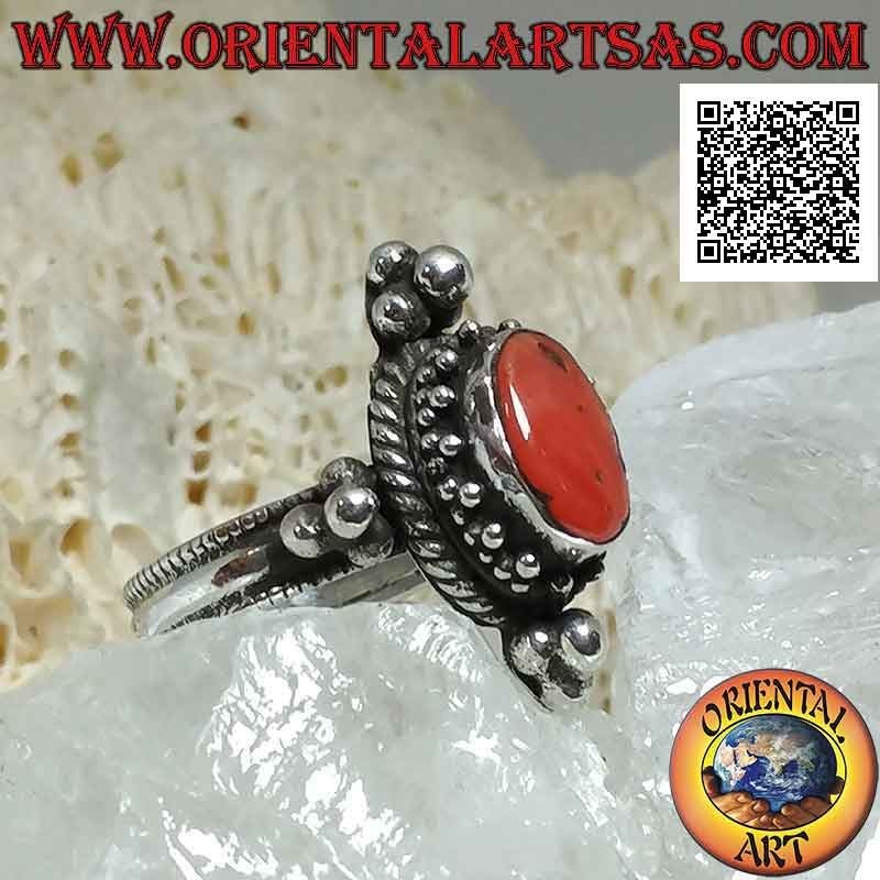 Bague en argent avec corail antique ovale entouré de trio de boules et entrelacs et tris sur les points cardinaux
