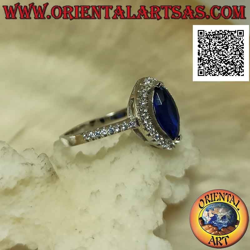 Solitaire style silver ring with synthetic shuttle sapphire surrounded by white zircons