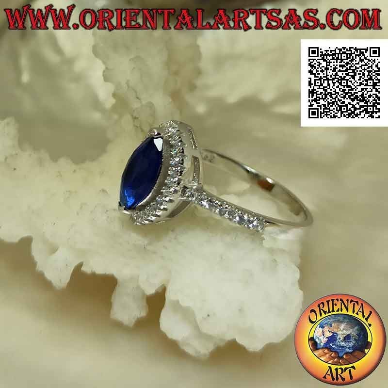 Solitaire style silver ring with synthetic shuttle sapphire surrounded by white zircons
