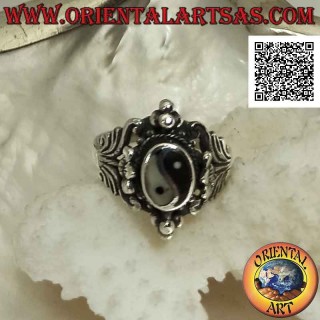 Silberring mit Yin Yang aus Onyx und Perlmutt in ethnischer Umgebung mit Blumendekorationen und Kugeln