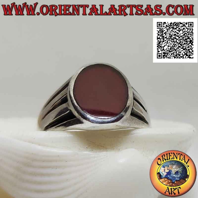 Anillo de plata lisa con cornalina ovalada al ras del borde y triple línea de media luna grabada en los lados