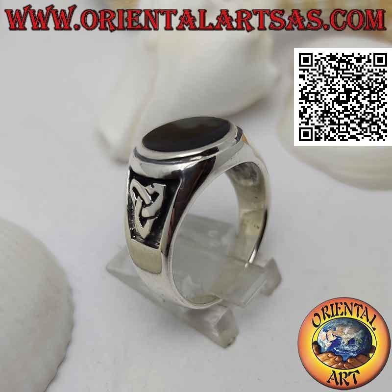 Silver ring with round onyx flush with raised edge and bas-relief triquetra on the sides