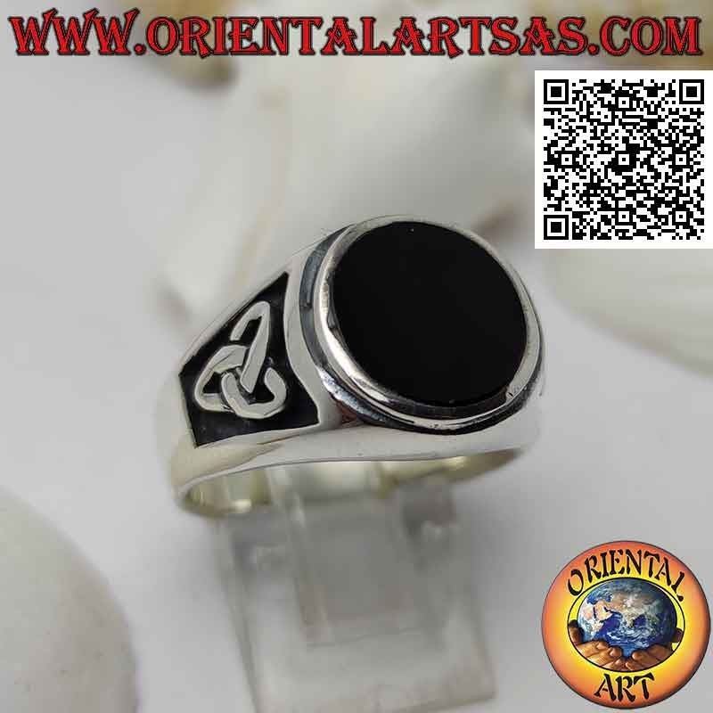 Silver ring with round onyx flush with raised edge and bas-relief triquetra on the sides