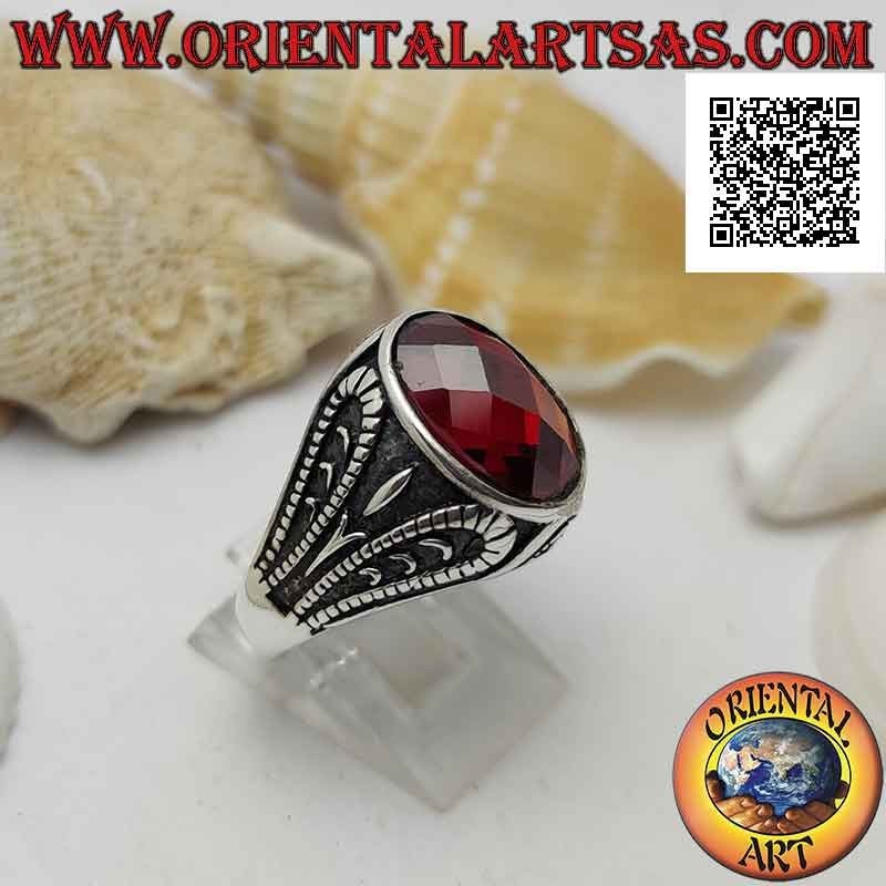 Silberring mit facettiertem ovalem Granat und oxidierter grotesker Reliefdekoration