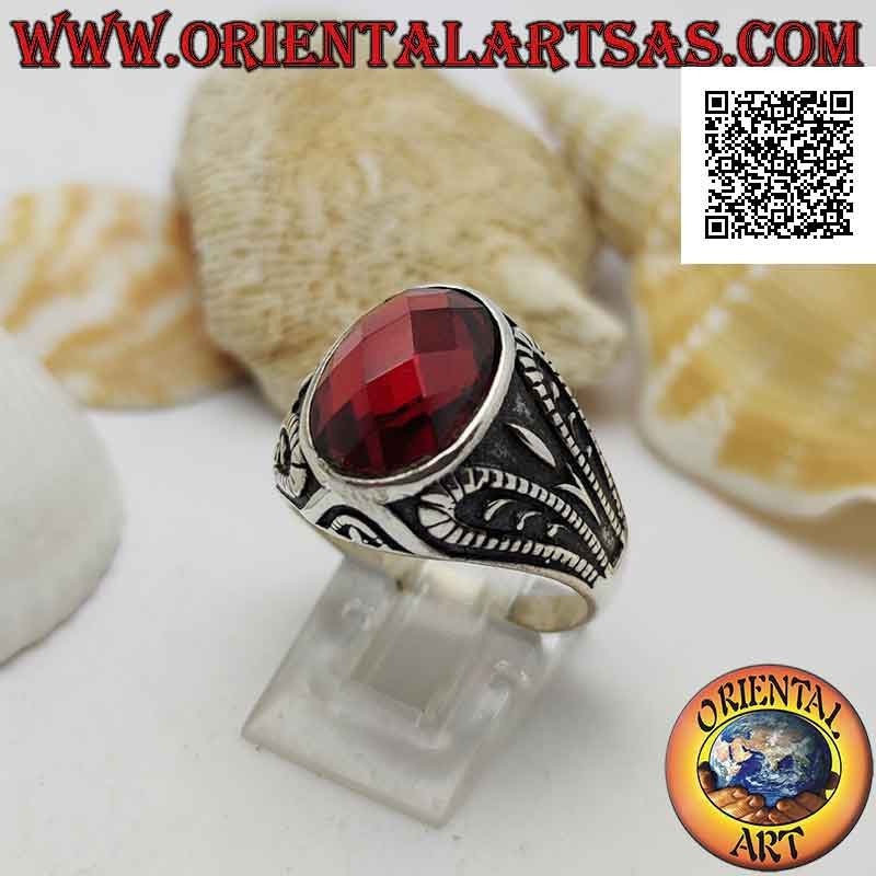 Silberring mit facettiertem ovalem Granat und oxidierter grotesker Reliefdekoration