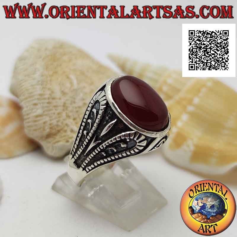 Silver ring with faceted oval carnelian and bas-relief oxidized grotesque decoration