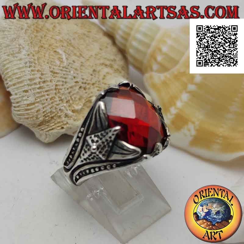 Silver ring with set faceted oval garnet and pointed decoration in high relief