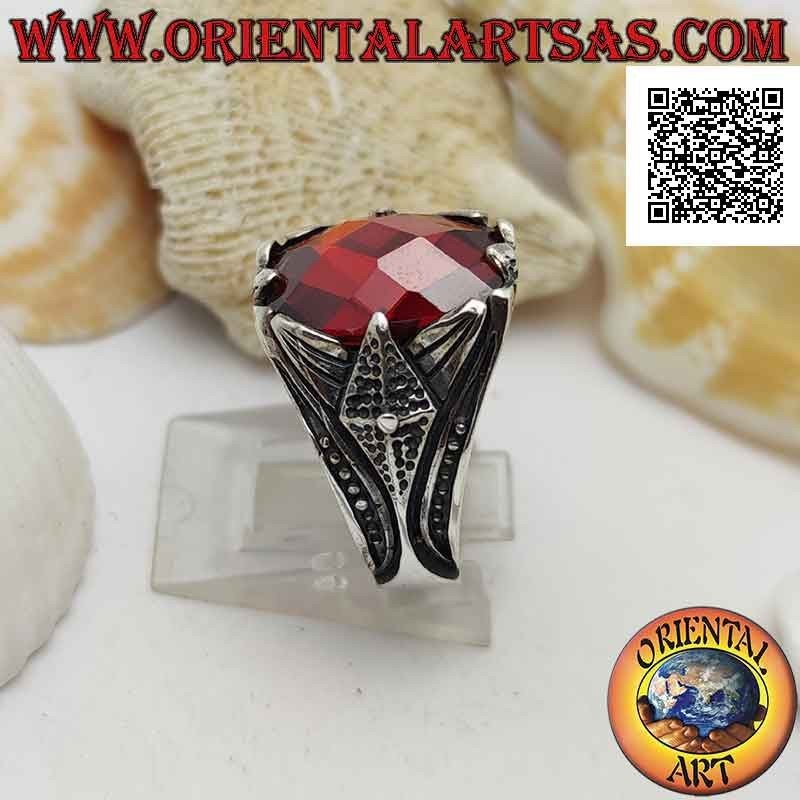 Silver ring with set faceted oval garnet and pointed decoration in high relief