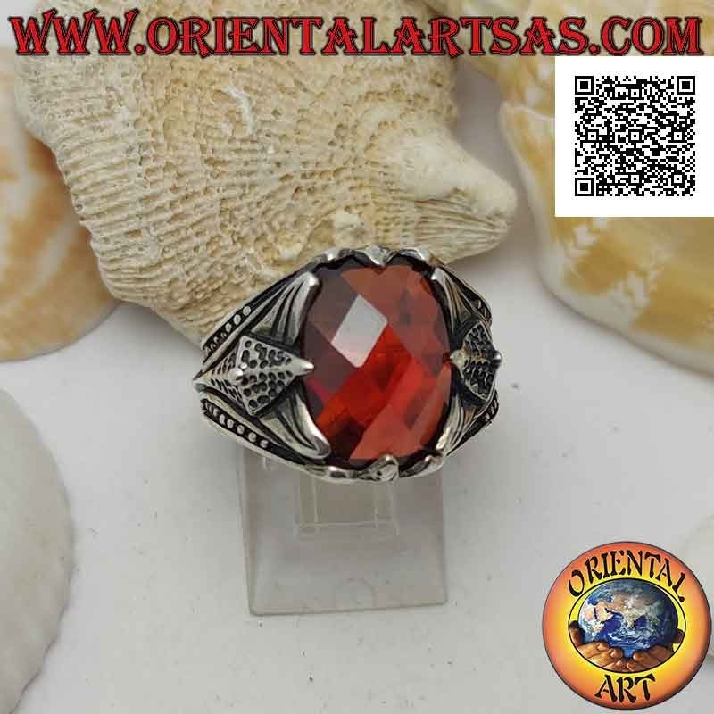 Silver ring with set faceted oval garnet and pointed decoration in high relief