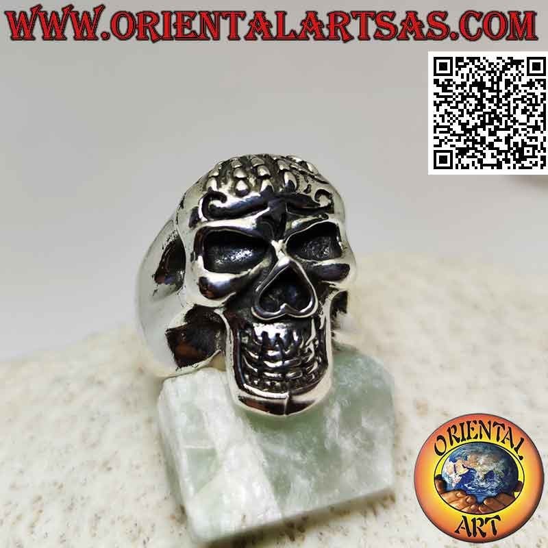 Silver ring in the shape of a skull possessed with hand on the forehead