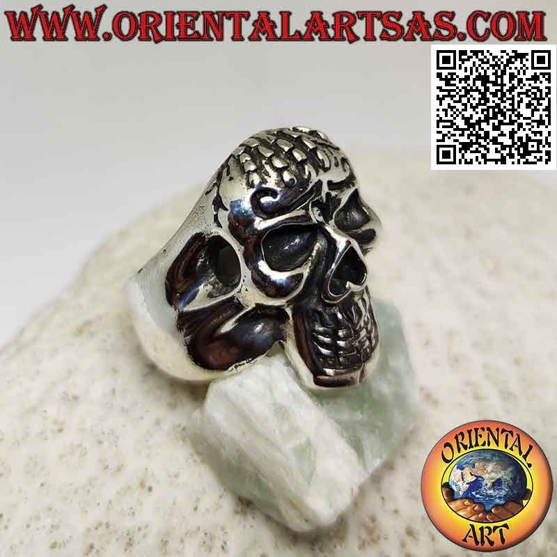 Silver ring in the shape of a skull possessed with hand on the forehead
