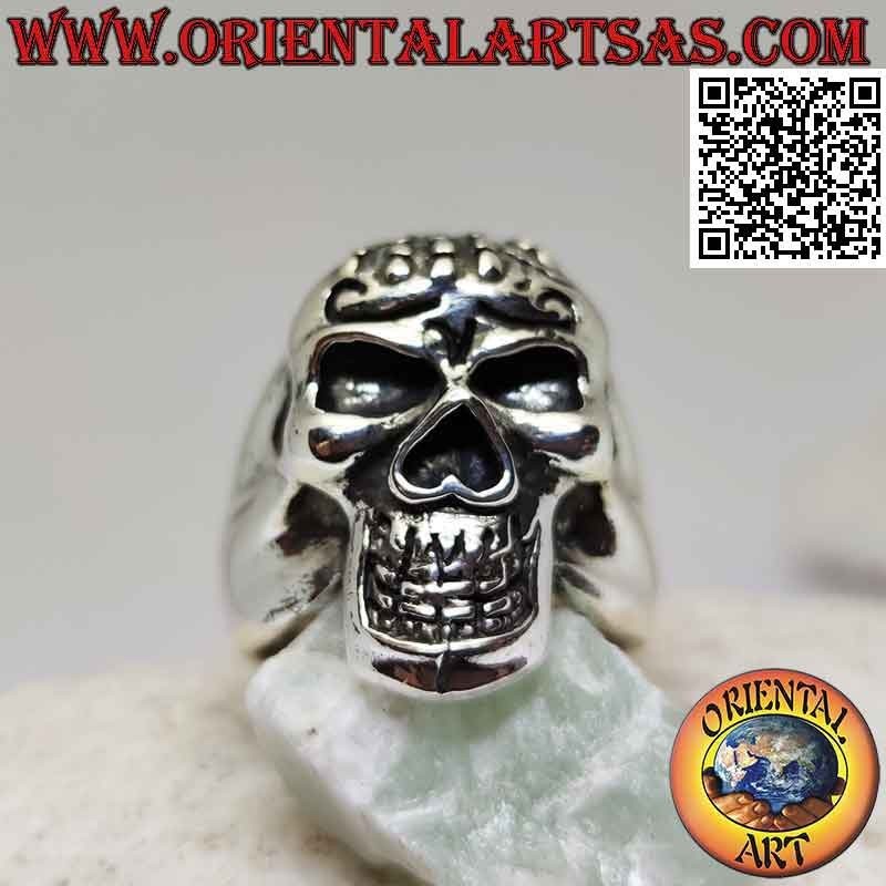 Silver ring in the shape of a skull possessed with hand on the forehead
