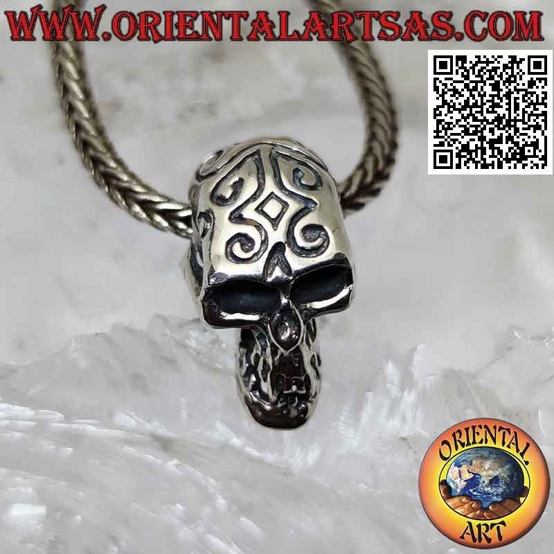 Silver pendant in the shape of a skull with engraved Maori and pierced temples