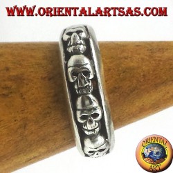 Anillo de banda en plata 925 con decoración de calaveras en fila en altorrelieve y acabado envejecido.