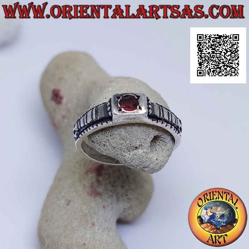 Silver ring with round garnet set in a raised square and checkered decoration