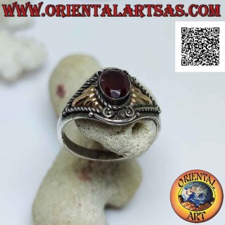 Ethnic style silver ring with oval cabochon garnet and 14 karat gold plates on the sides