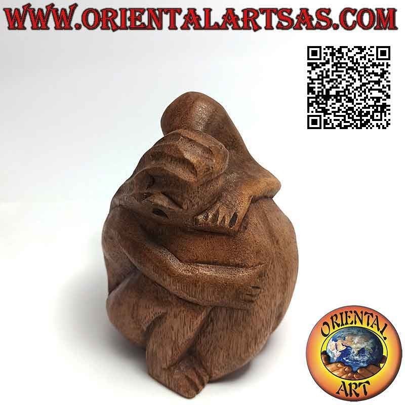 Scultura di una coppia in abbraccio consolatorio in legno di suar