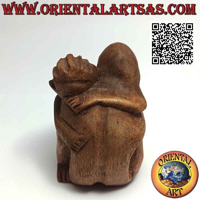 Escultura de pareja en abrazo consolador en madera de suar