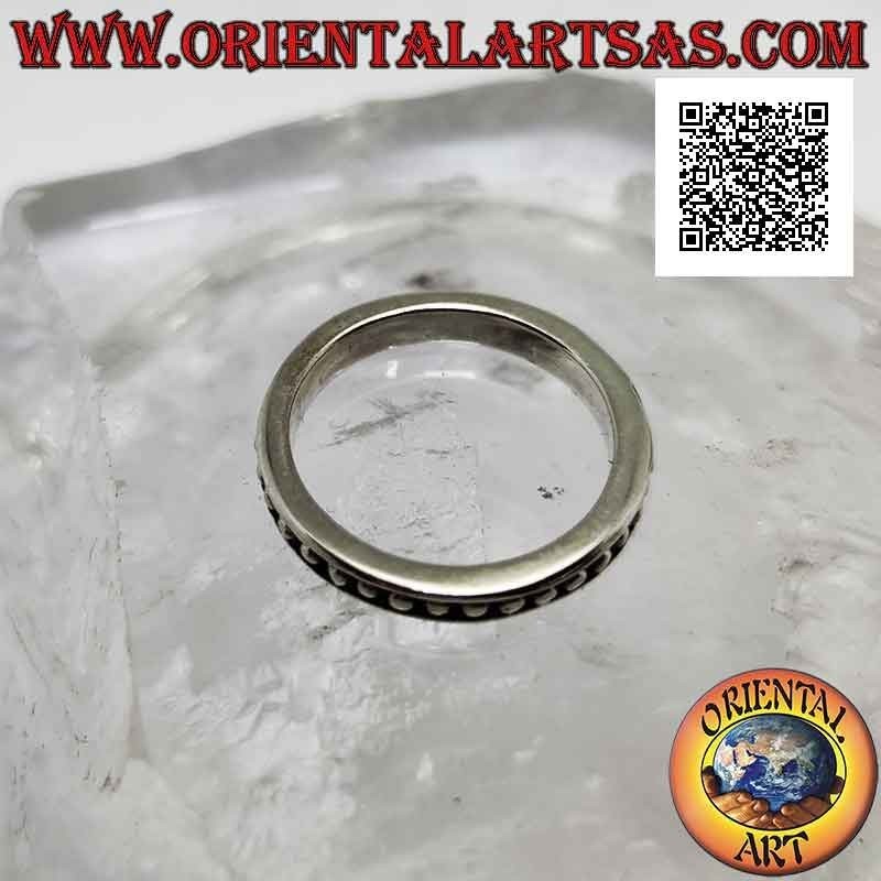 Anillo de plata con pequeñas esferas lisas sobre un fondo en bajorrelieve