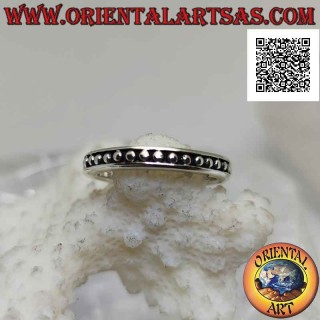 Silver band ring with small smooth spheres on a bas-relief background