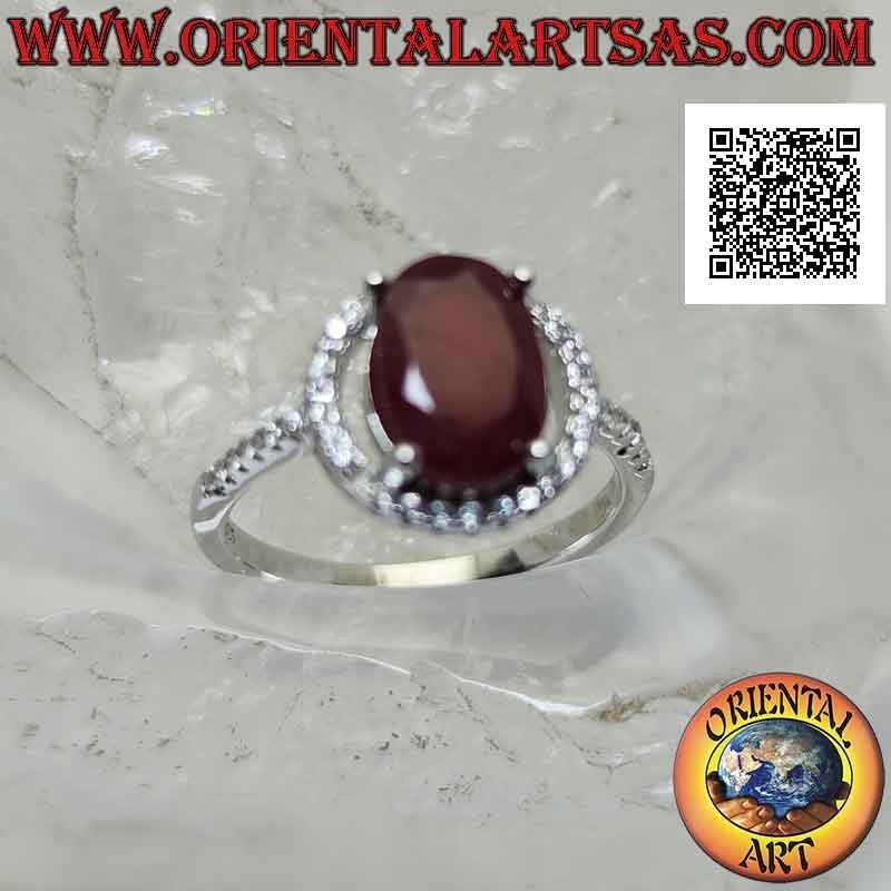 Silver ring with oval synthetic ruby set surrounded by zircons