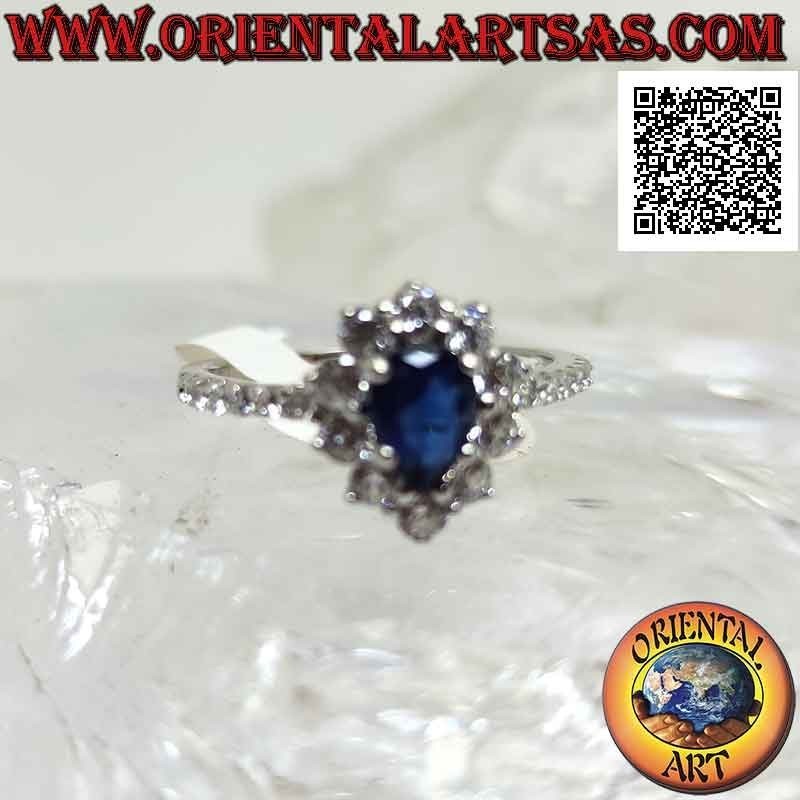 Silver ring with synthetic teardrop sapphire surrounded by round white zircons and on the sides