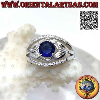 Silver ring with round synthetic sapphire set between elliptical games of white zircons