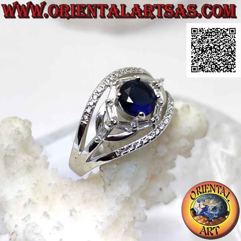 Silver ring with round synthetic sapphire set between elliptical games of white zircons