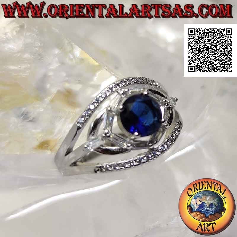 Silver ring with round synthetic sapphire set between elliptical games of white zircons