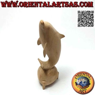 Sculpture of a dolphin juggling between two 15 cm hibiscus wood balls