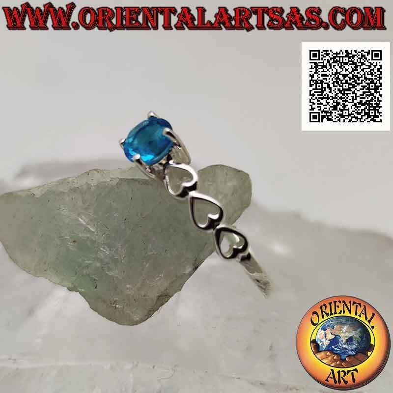 Solitaire silver ring with round synthetic blue topaz set and perforated hearts on the sides