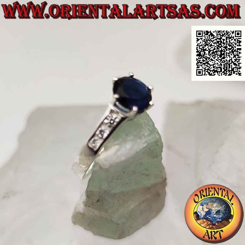 Solitaire silver ring with round synthetic sapphire set in relief and zircons on the sides
